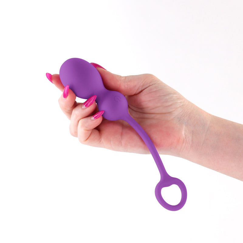 A violet silicone vibe with a loop handle held in a hand.