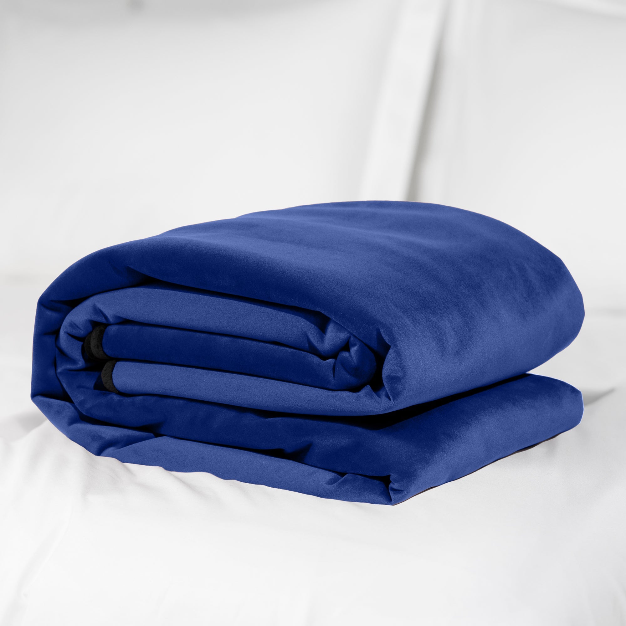 A royal blue microvelvet waterproof throw blanket folded on a white surface.