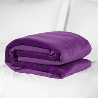 A folded aubergine microvelvet sex throw on a white surface.
