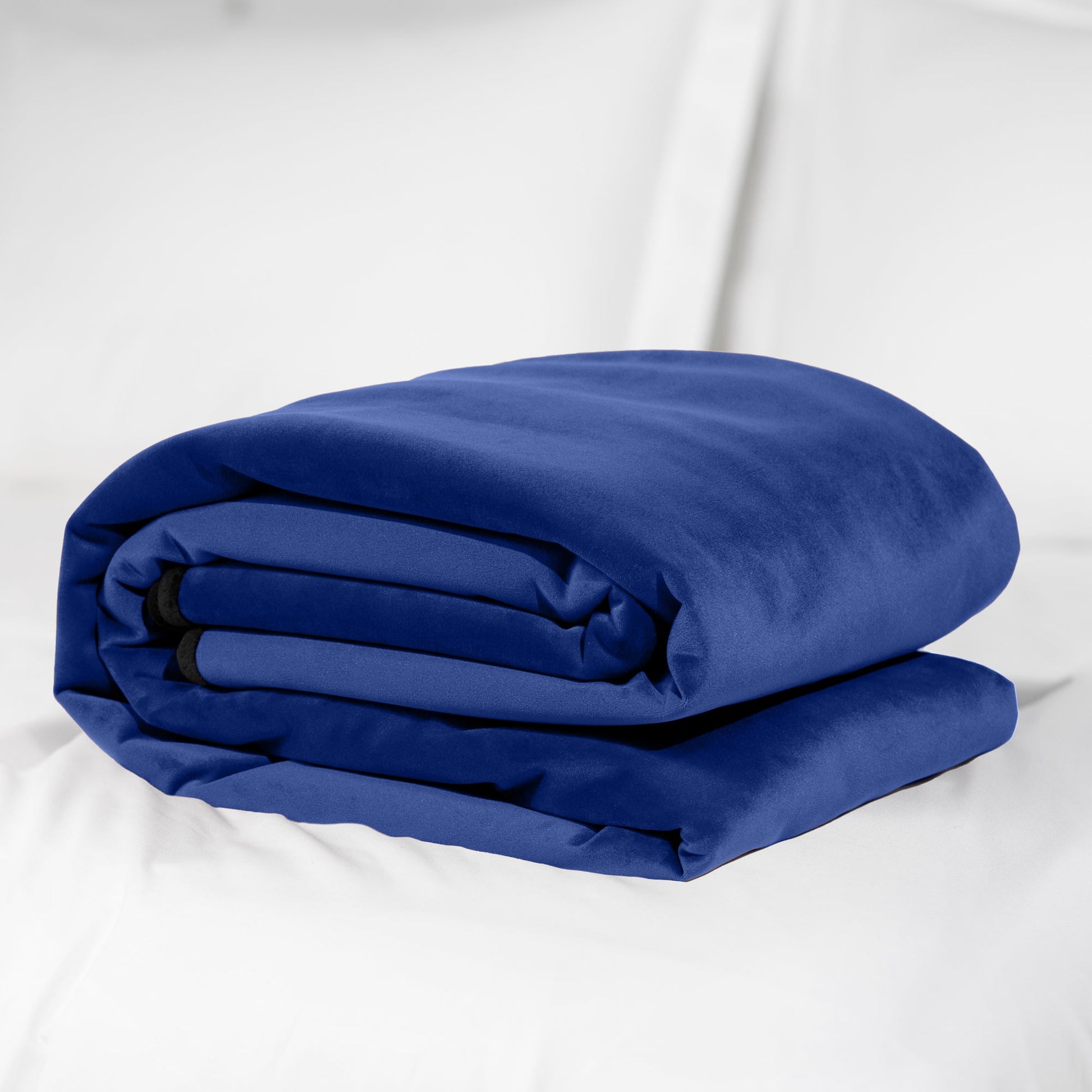 Royal blue waterproof travel throw blanket folded on a white surface.