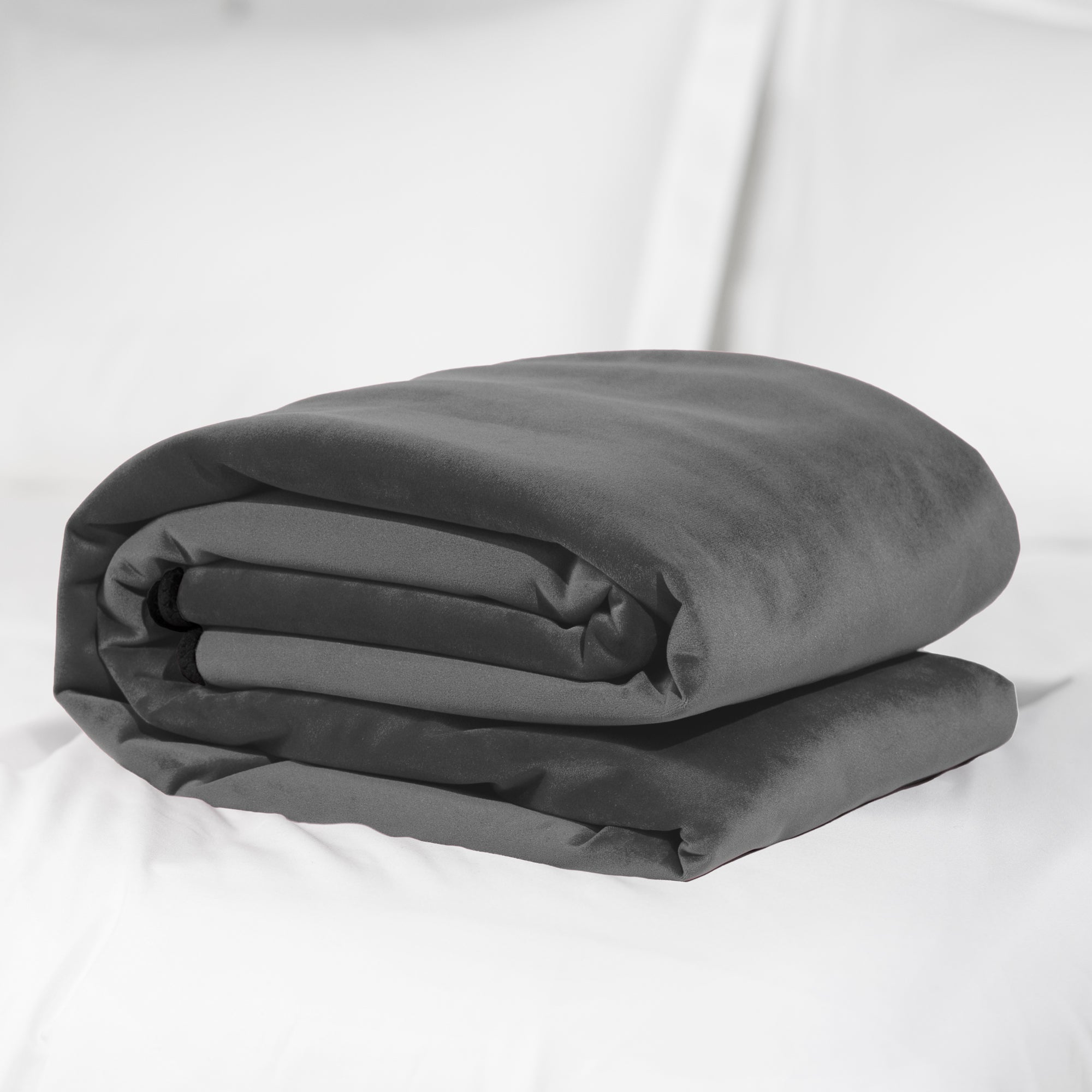Grey waterproof microvelvet sex throw folded on a white surface.