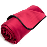 Rolled up red waterproof microvelvet throw with black trim.