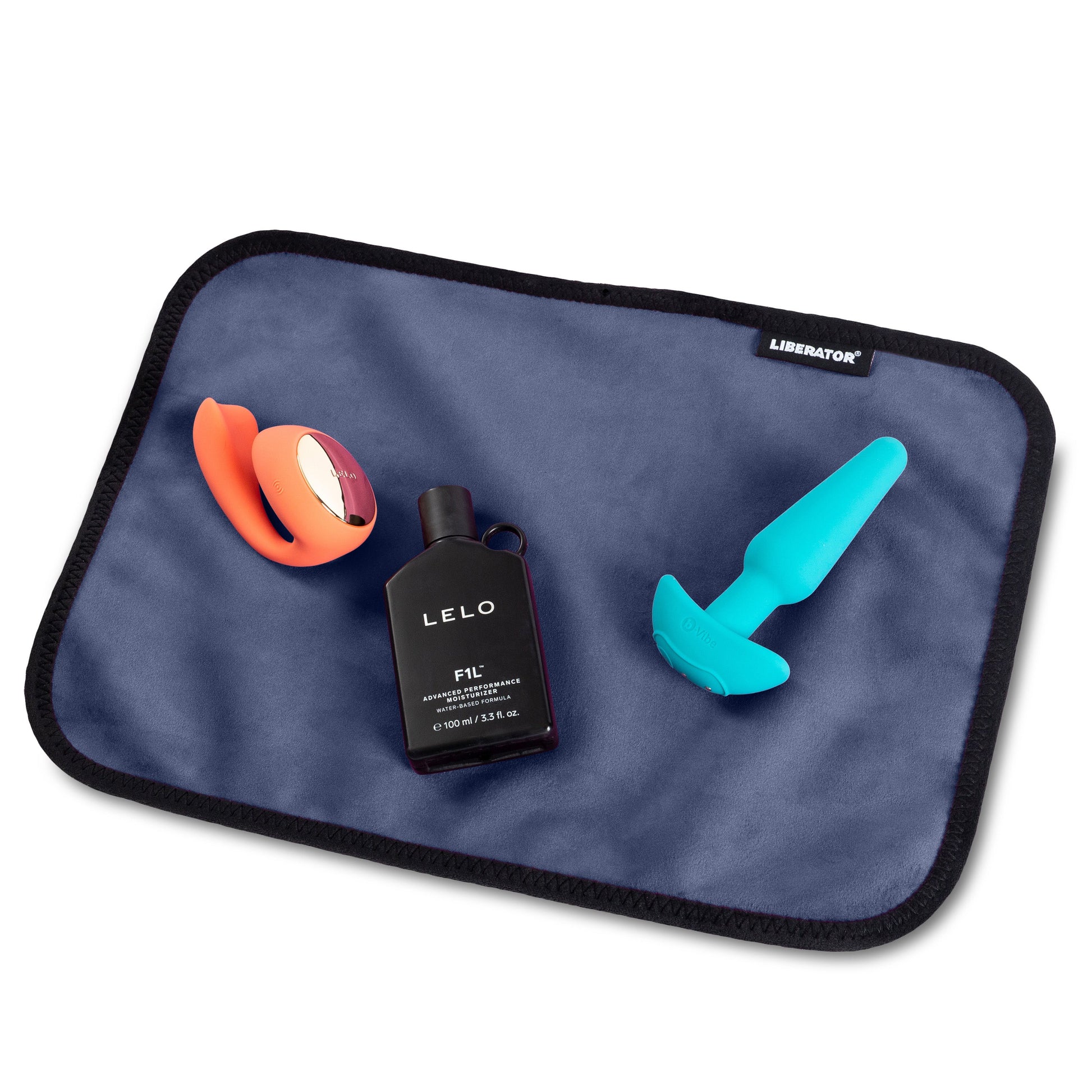 Indigo moisture-proof microvelvet toy pad with two adult toys and a bottle of lubricant.