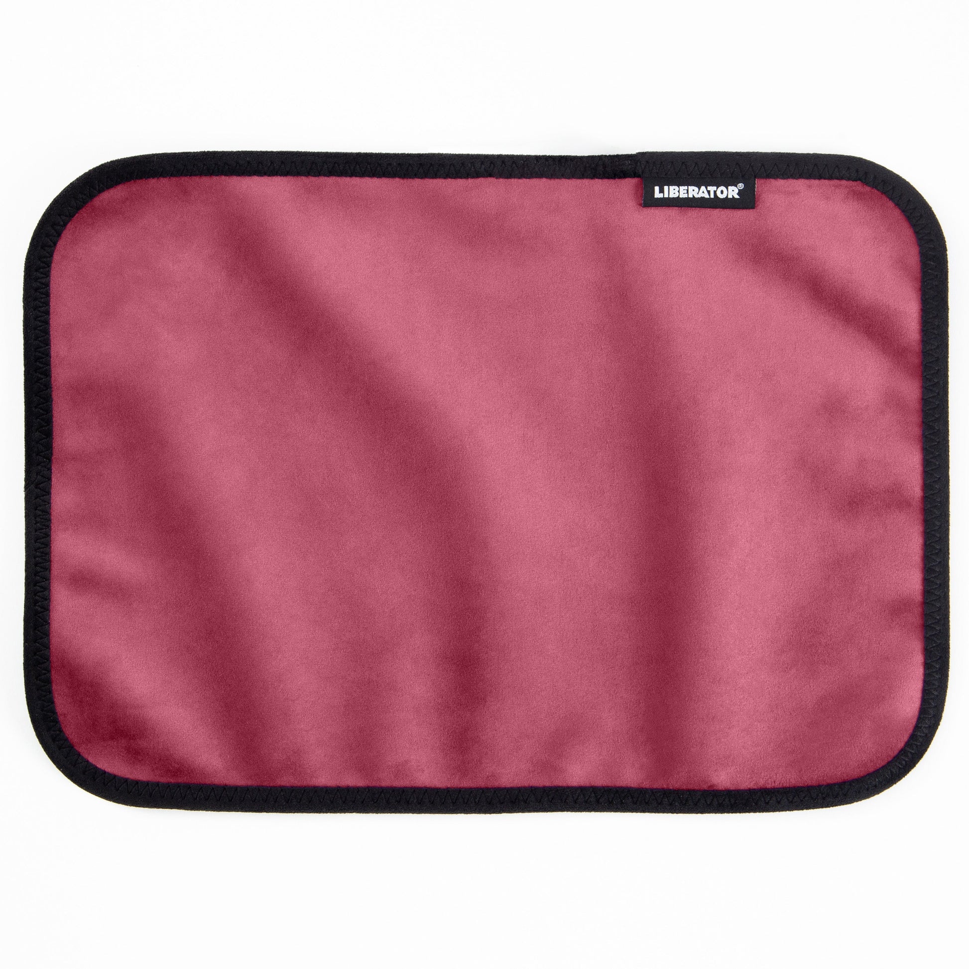 A rectangular pink microvelvet mat with a black stitched border and a Liberator logo.