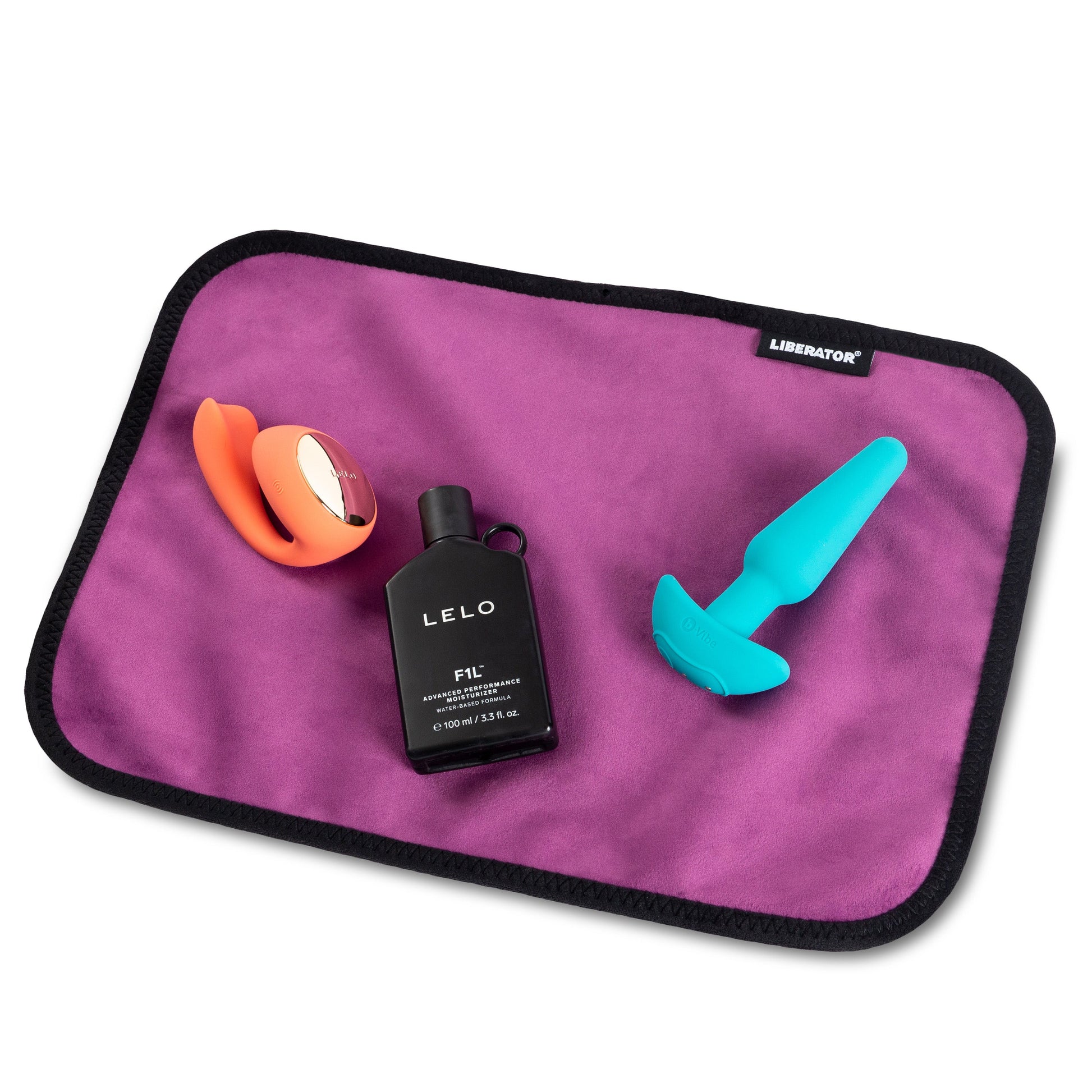 Aubergine microvelvet toy pad with a vibrator, lubricant, and another toy.