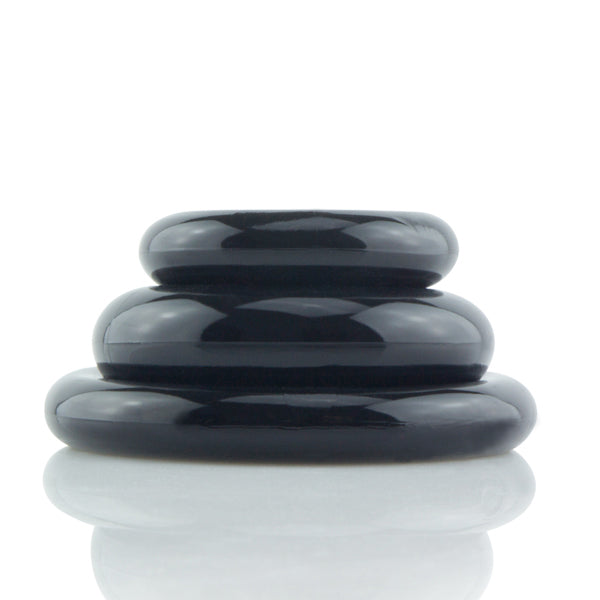 Three black stretchy cock rings stacked on top of each other.
