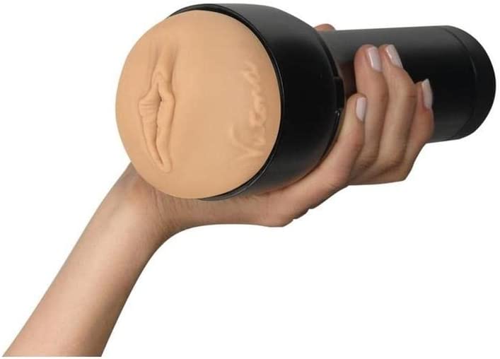 A hand holds a black and tan automatic stroker with a textured opening.