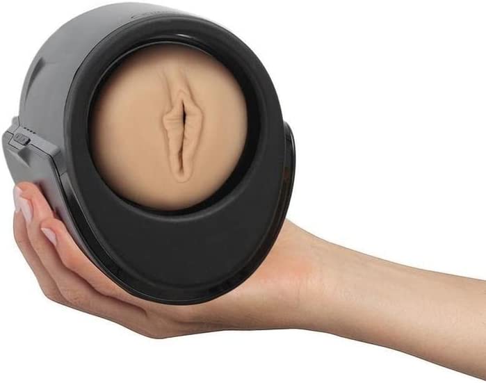 A hand holds a black automatic stroker with a realistic flesh-toned insert.
