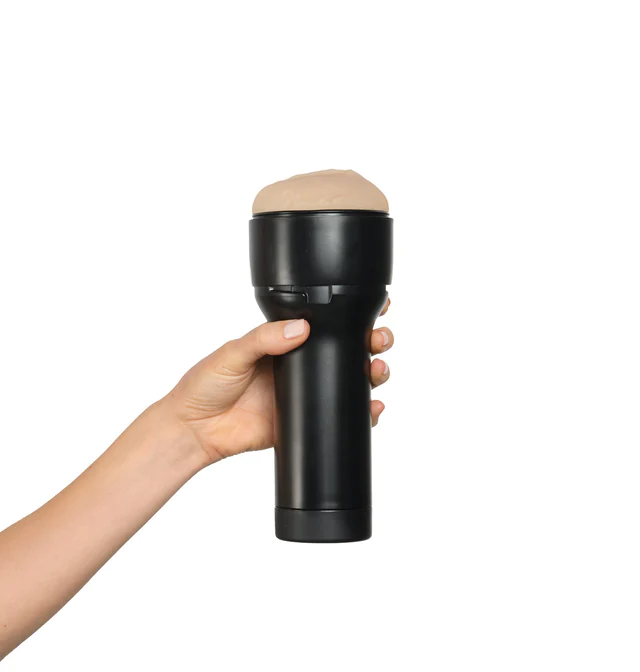 A hand holds a black stroker with a tan, ribbed sleeve.