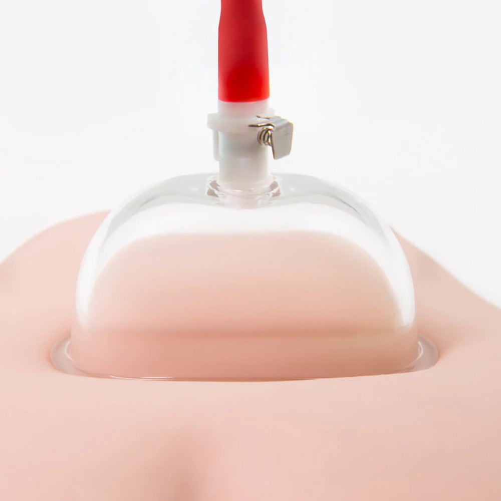 A clear acrylic cup with a red pump attachment on a pink surface.