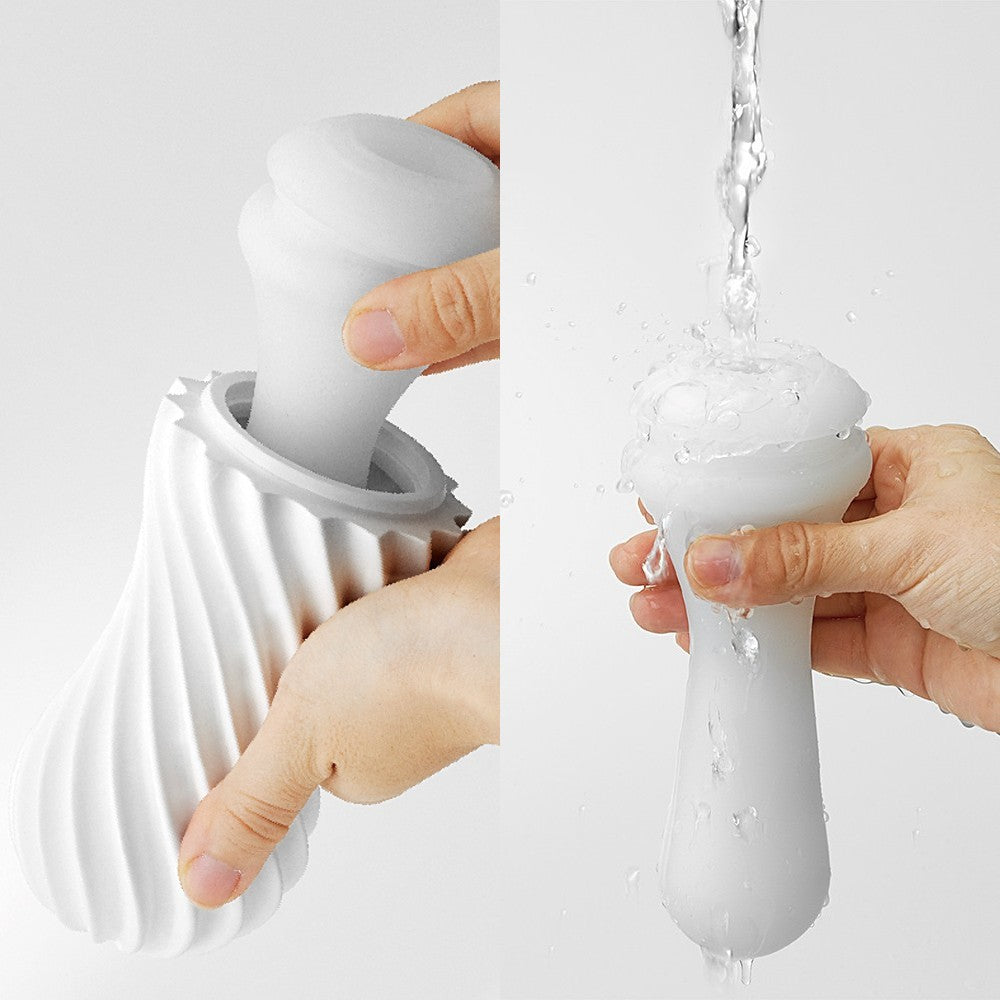 White reusable spiral stroker being cleaned under water.