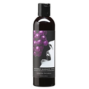 Bottle of edible grape flavored massage oil with a label featuring grapes and a mouth.