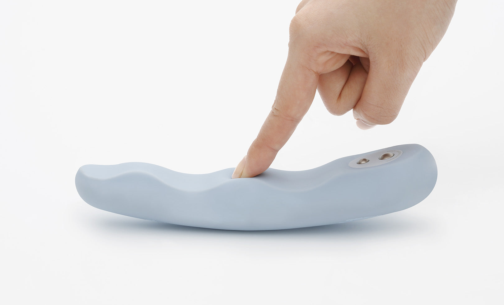 A light blue, flexible silicone vibrator with a wave design is being touched by a finger.