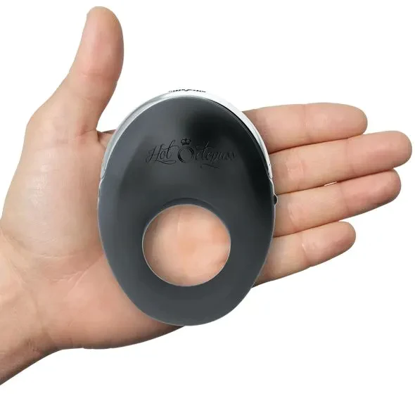 A black vibrating cock ring with a circular opening, held in a hand.