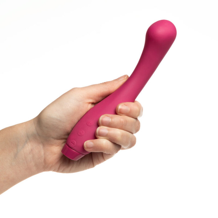 A fuchsia Juno G-spot and clitoral vibrator held in a hand.