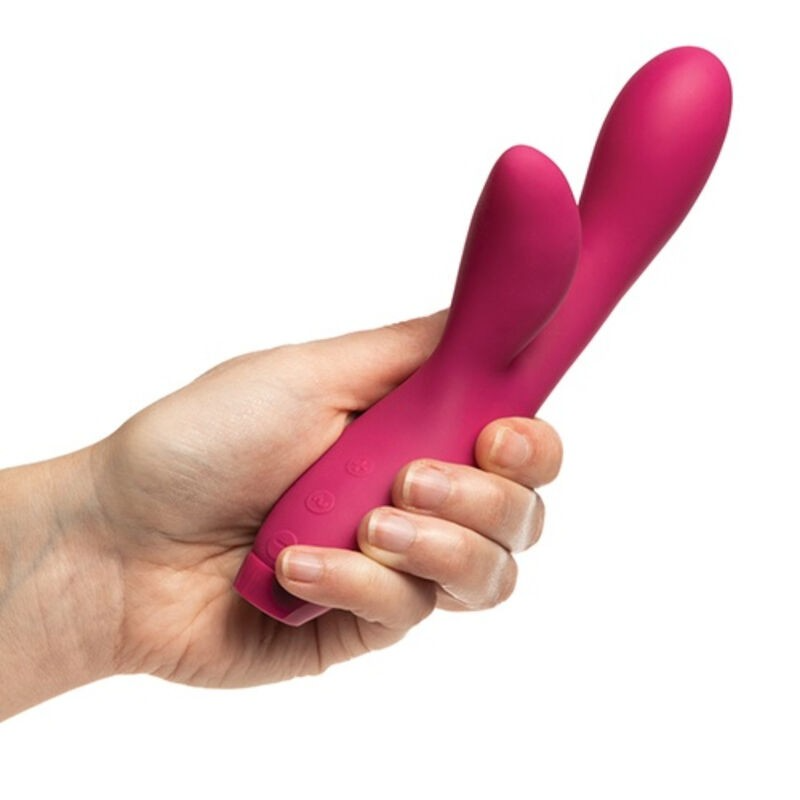 A pink rabbit-shaped vibrator with two ears held in a hand.
