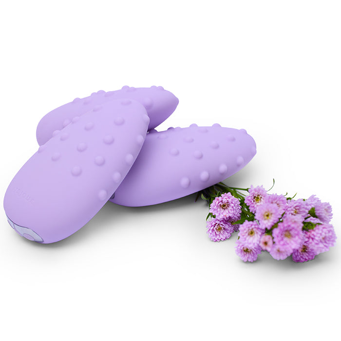 Three lavender clitoral vibrators with raised dots and a small bouquet of purple flowers.