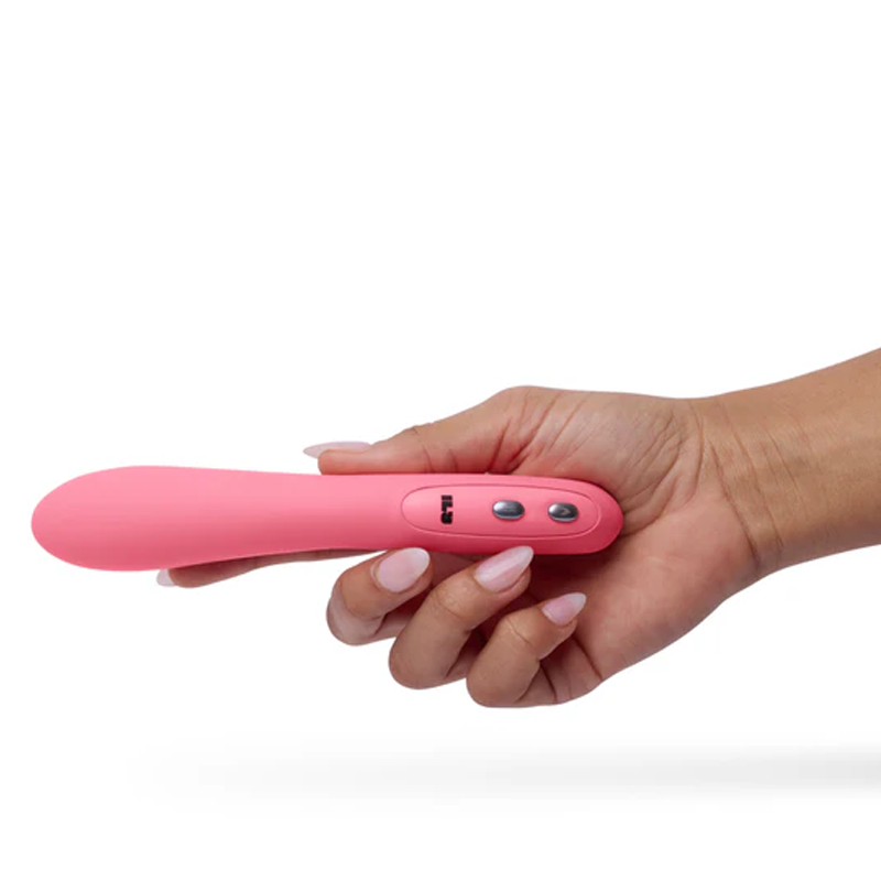 A pink wand vibrator held in a hand with three control buttons.
