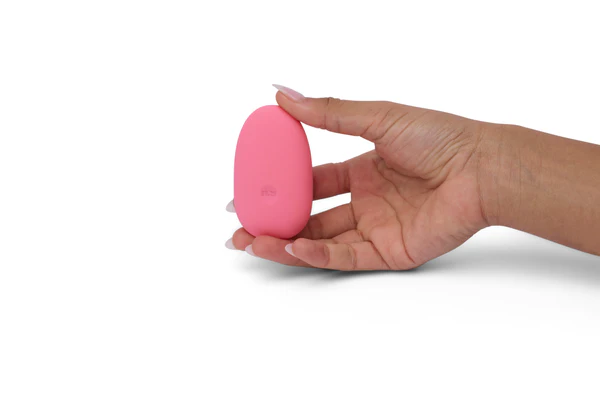 A pink pebble-shaped vibrator held in a hand.