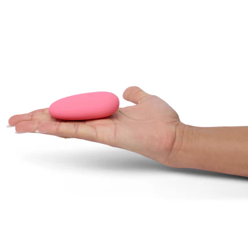 Pink pebble-shaped silicone clitoral vibrator held in a hand.