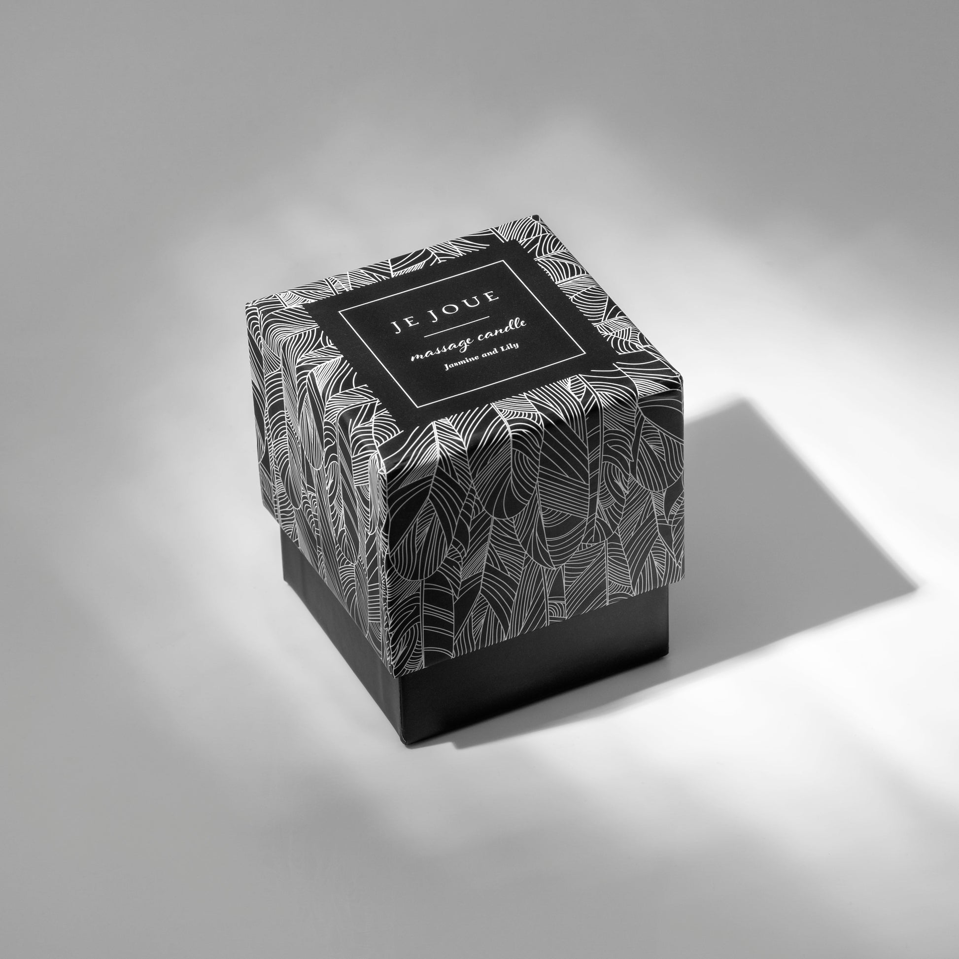 Jasmine and Lily Je Joue massage candle in a black and white patterned box.