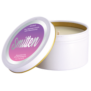 A white soy massage candle with a purple and pink label that says "Smitten" and "Strawberries & Champagne".