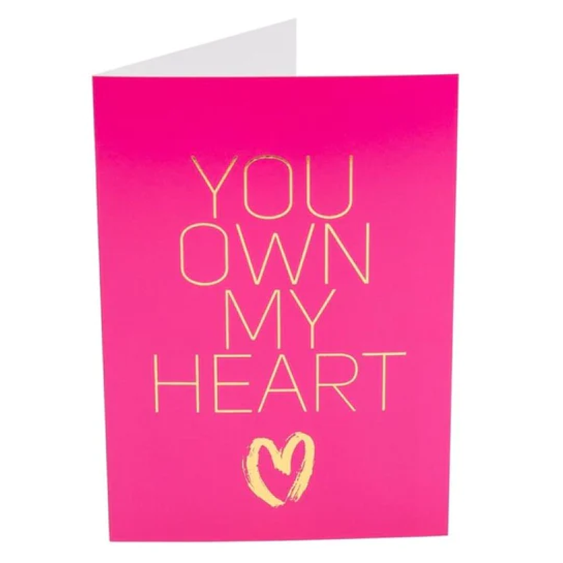 A pink card with gold text that says "YOU OWN MY HEART" and a heart symbol.