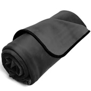 A black waterproof travel throw blanket rolled up.