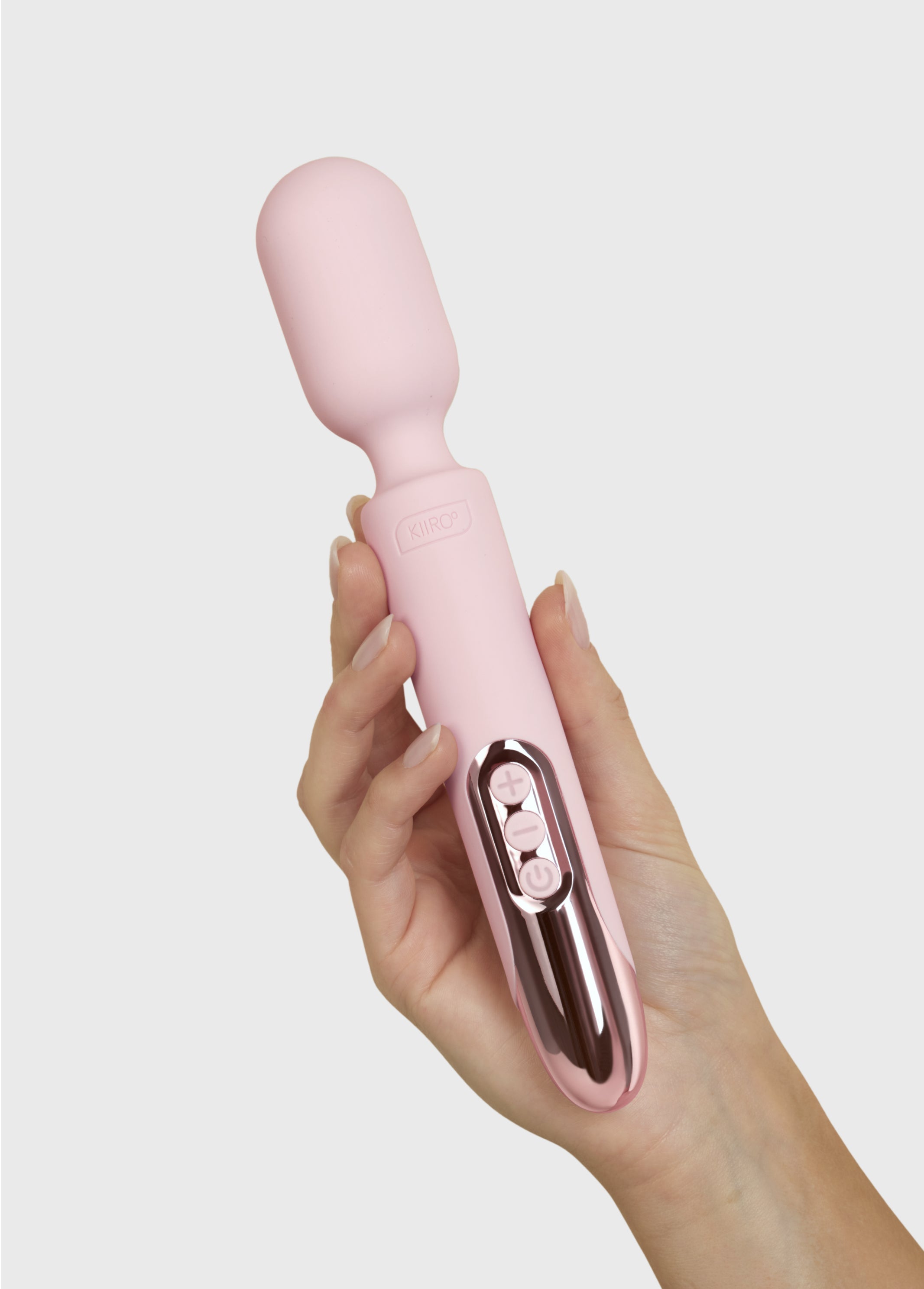 A pink Kiiroo ProWand wand vibrator held in a hand.