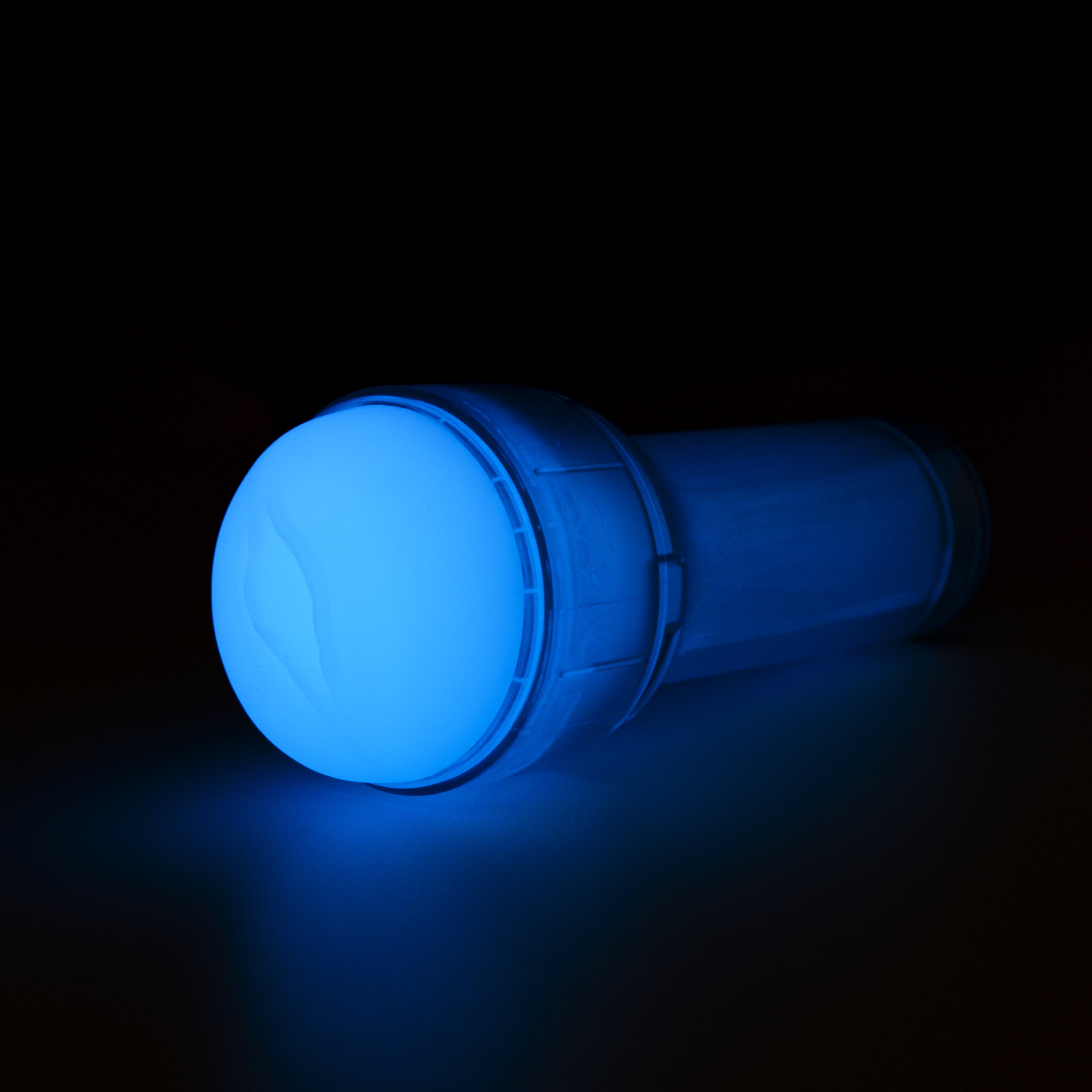 A blue glow-in-the-dark stroker with a textured sleeve.