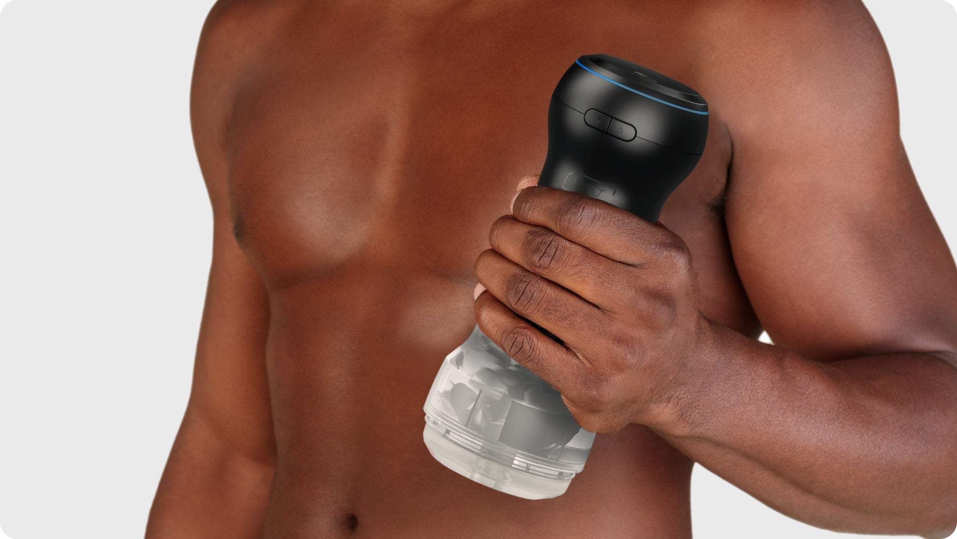 A man holds a transparent Kiiroo Pocket Stroker with a black top.