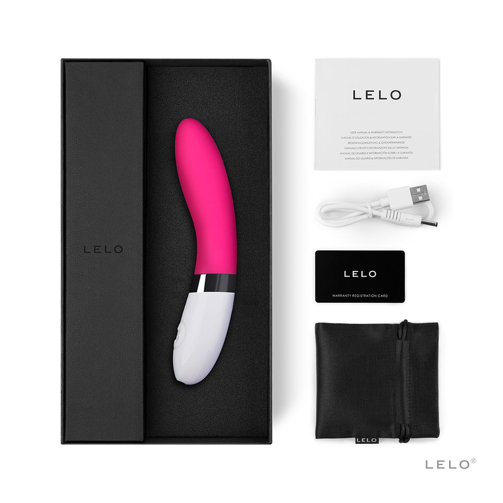 A pink and white Lelo vibrator with its box, charging cable, warranty card, and storage pouch.