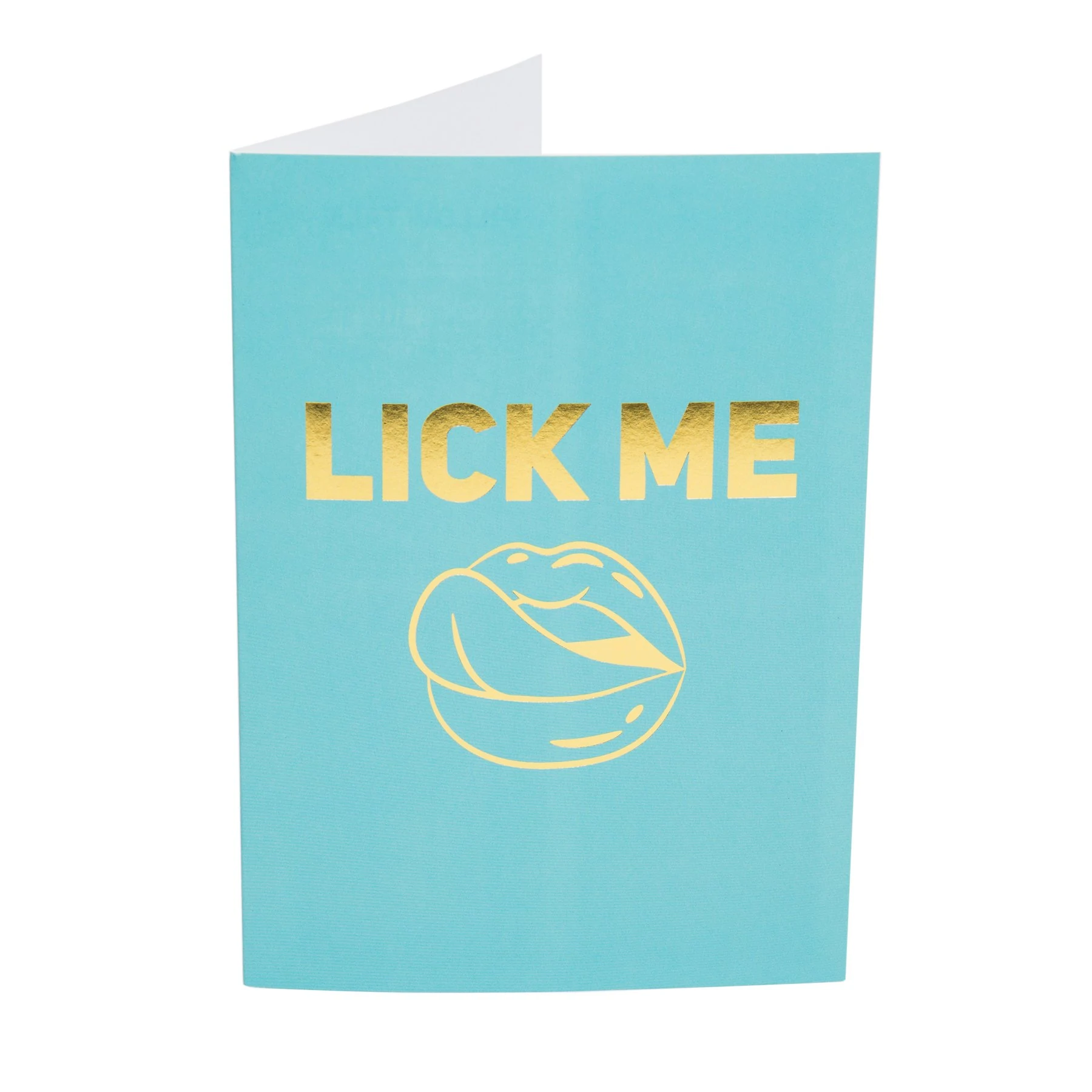 A turquoise card with gold foil text that says "LICK ME" and a gold foil illustration of lips with a tongue.