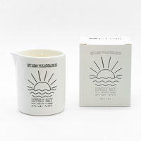White ceramic massage candle with sun and wave design.