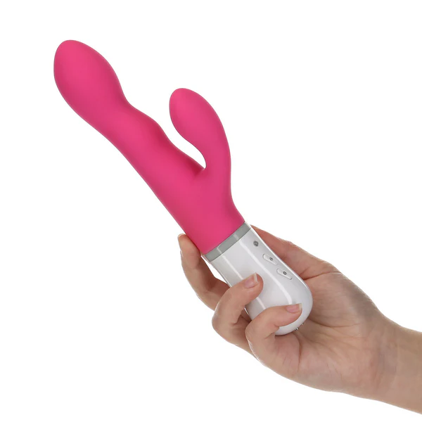 A pink rabbit vibrator with a white base held in a hand.
