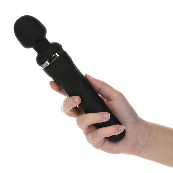 A black wand vibrator with a rounded head is held in a person's hand.