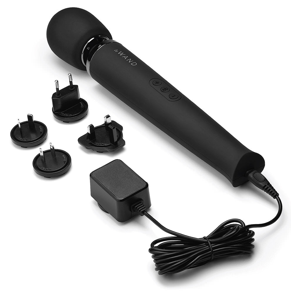 Black rechargeable wand massager with multiple plug adapters and charger.