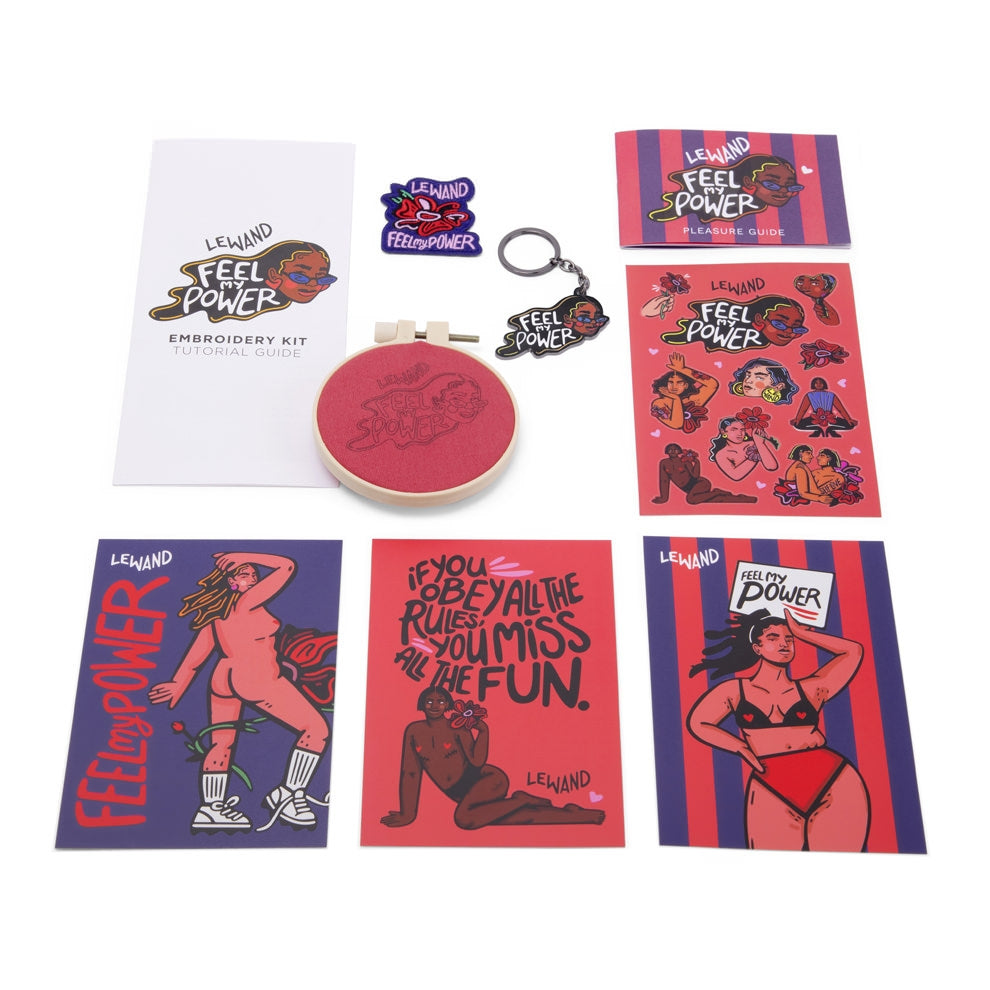 A collection of Le Wand "Feel My Power" themed items including a tutorial guide, embroidery kit, and stickers.