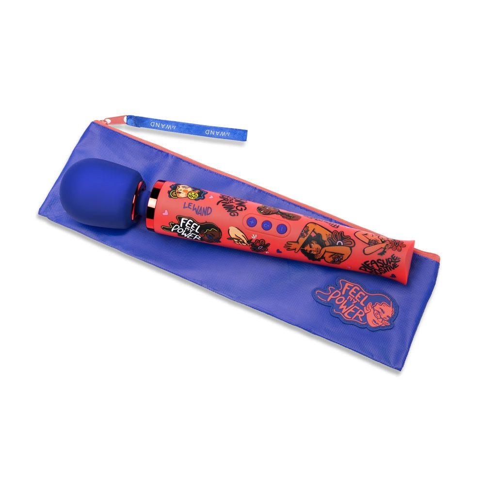 A red Le Wand vibrator with blue accents and graphics rests on a blue pouch.