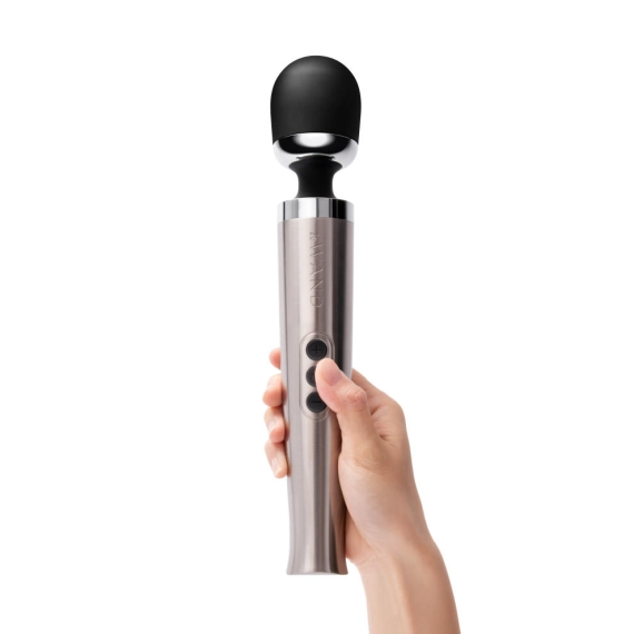 Silver die-cast metal wand massager with a black head held in a hand.
