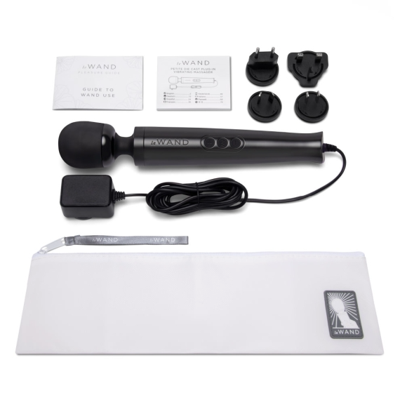 A black Le Wand massager with accessories including a power adapter, plug adapters, and a storage pouch.