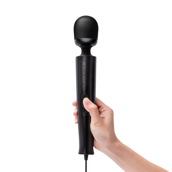 A black wand massager with a metal body held in a hand.