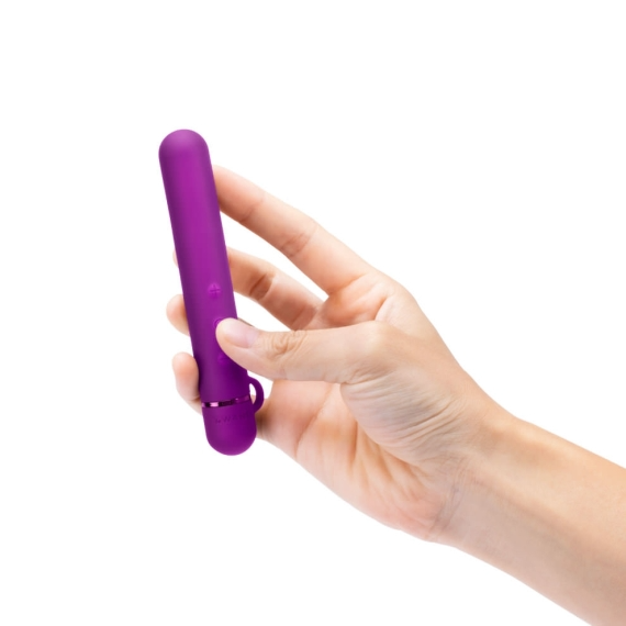 A hand holds a purple slim mini vibrator with a loop at the end.