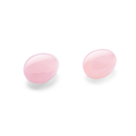 Two smooth, pink rose quartz yoni eggs on a white background.