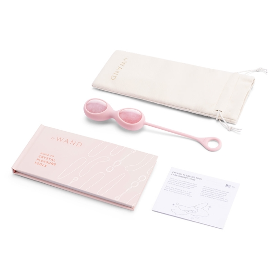 Rose quartz yoni eggs with a storage pouch, guide book, and care instructions.