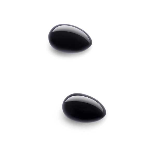 Two polished black obsidian yoni eggs on a white background.