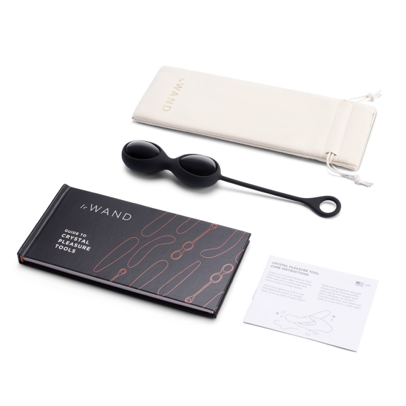 Black obsidian yoni eggs with a storage pouch, guide book, and care instructions.