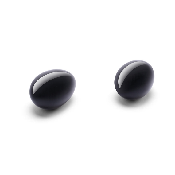 Two smooth, black obsidian yoni eggs on a white background.