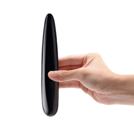A hand holds a smooth, black obsidian crystal wand massager.