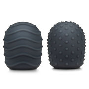 Two dark grey silicone texture covers for a massager, one with wavy lines and one with raised dots.